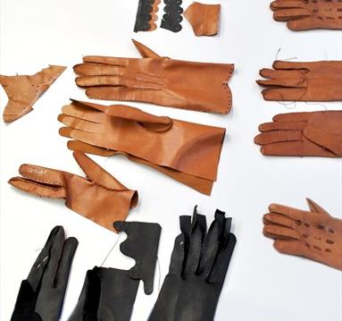 The image shows a variety of different sizes of leather gloves in coulors of black, light brown and dark brown