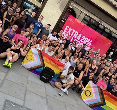 Group shot of participants in 5km run displaying Pride flags.
