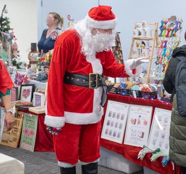 Santa and his Elf browsing at the Christmas market