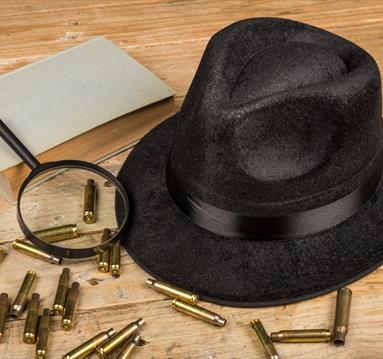 Photo of a bowler hat, bullet casings and an eye glass