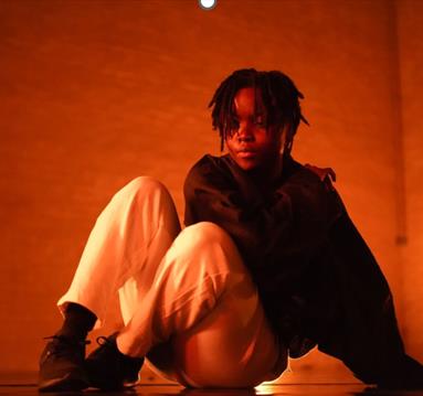 Image of young person sat down on the floor