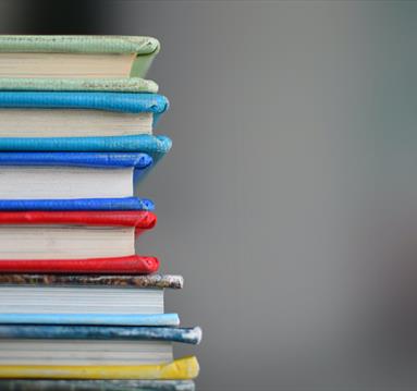 Photo of a stack of colourful books.
