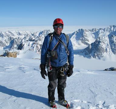 Photo of mountaineer Simon Yates on top of a snow covered mountain.