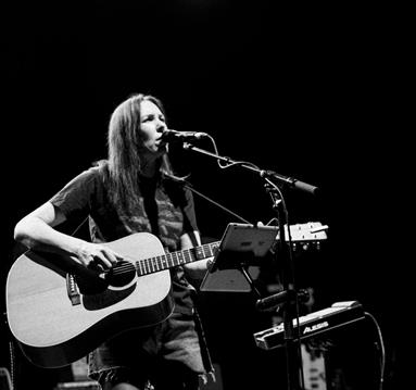 Black and white photo of Thea Gilmore on stage with a guitar