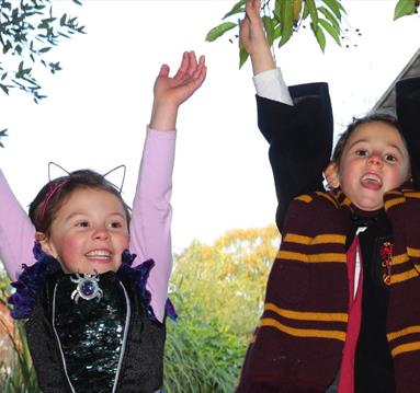Photo of two young kids dressed as a witch and wizard