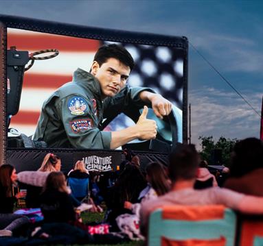 Photo of an outdoor cinema screen showing a still from Top Gun.