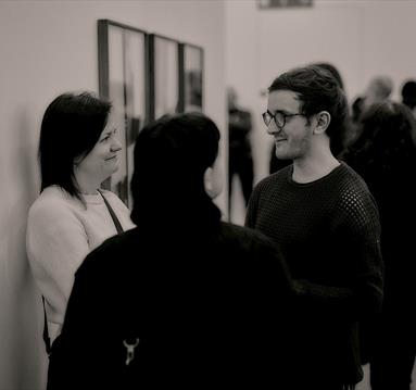 Black and white photo of visitors in the gallery