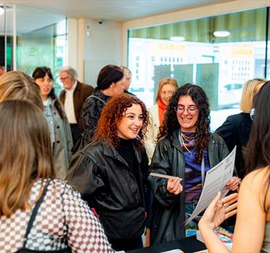 Photo of attendees mignling at an exhibition opening