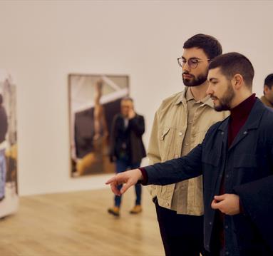 Photo of people looking at the gallery pieces