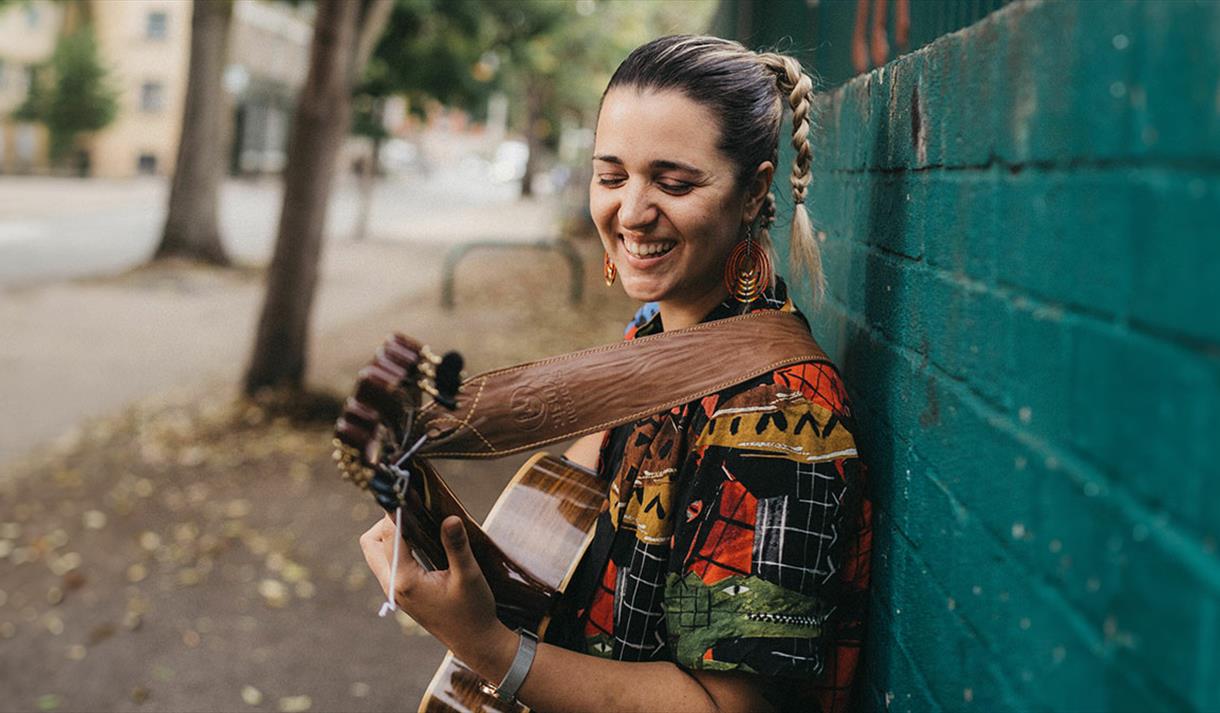 woman smiling playing guitar