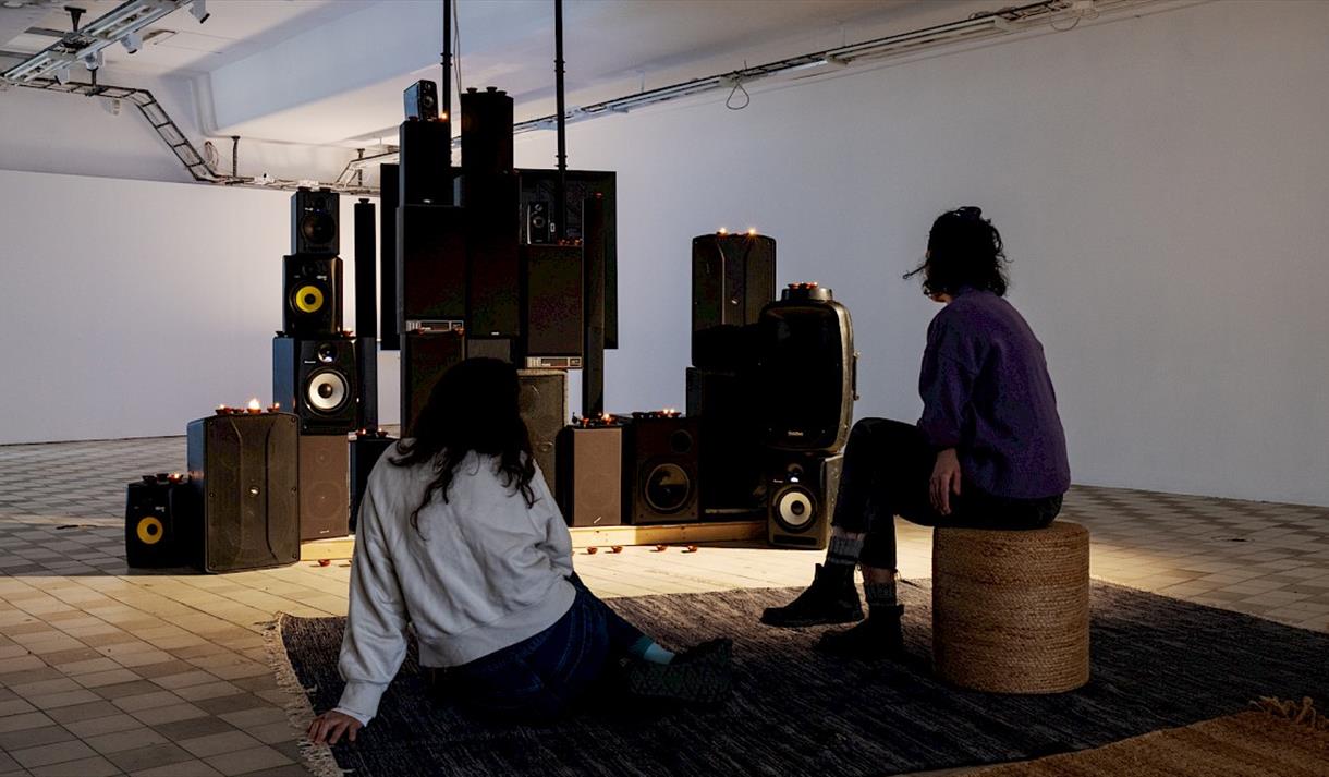 two people in front of speakers