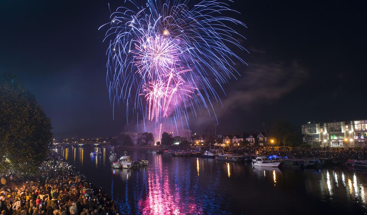 A display of fireworks in the night sky over the river at Victoria Embankment, crow are watching them go up.