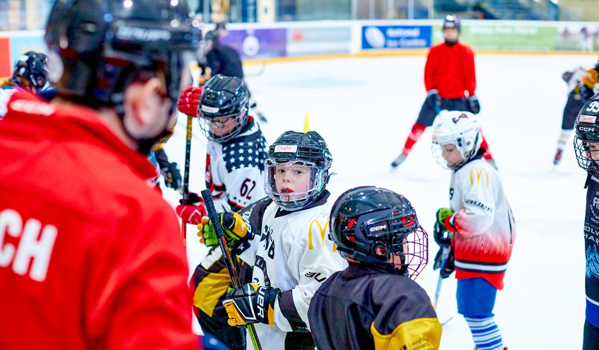 Photo of a coach with young ice hockey students