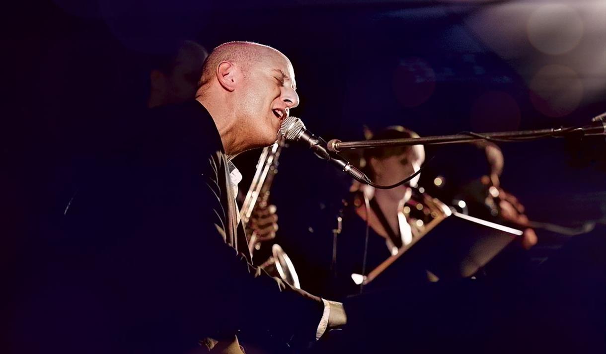 Jeremy Sassoon sings at a gig with his band