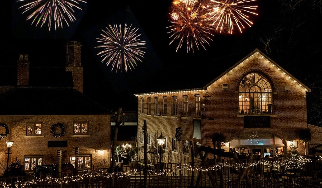 Fireworks behind the Engine Yard. The sky is dark and the fireworks stand out against the night sky.