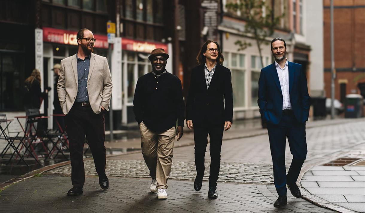 Photo of Sharp Little Bones ft Tony Kofi walking down a street