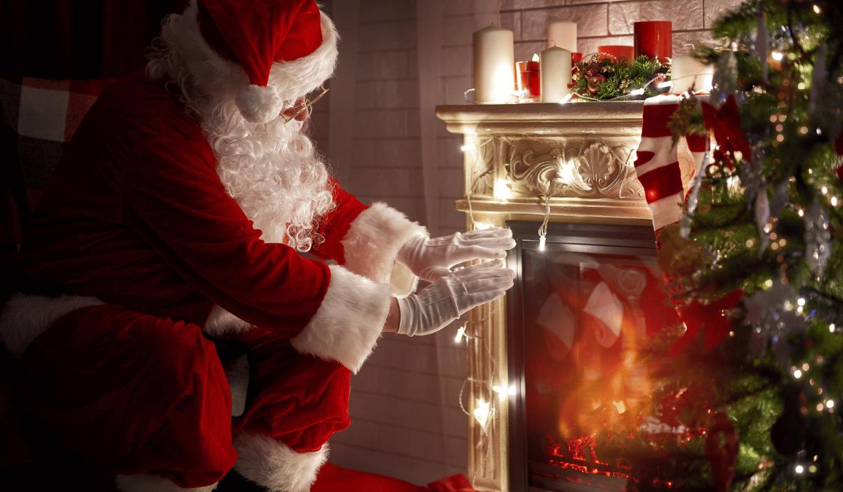 Photo ofSanta sitting at a fireplace