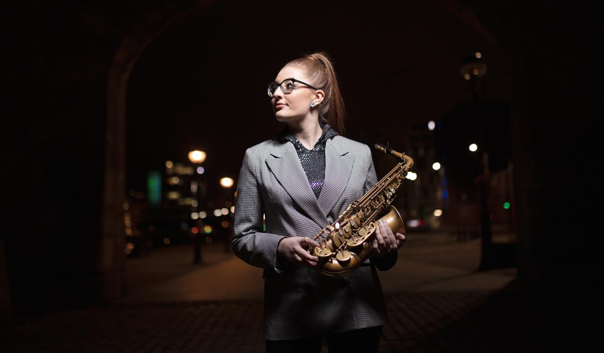 Jess Gillam holds her saxophone ready to perform