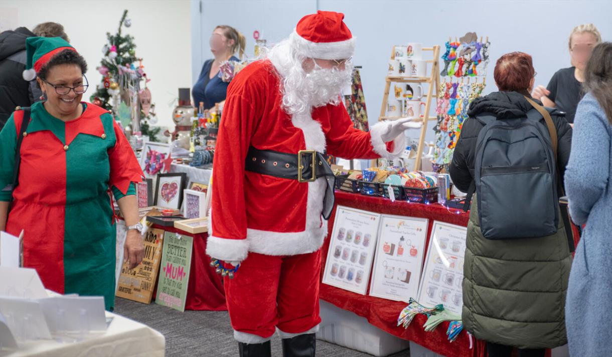 Santa and his Elf browsing at the Christmas market