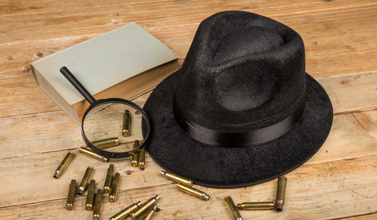 Photo of a bowler hat, bullet casings and an eye glass