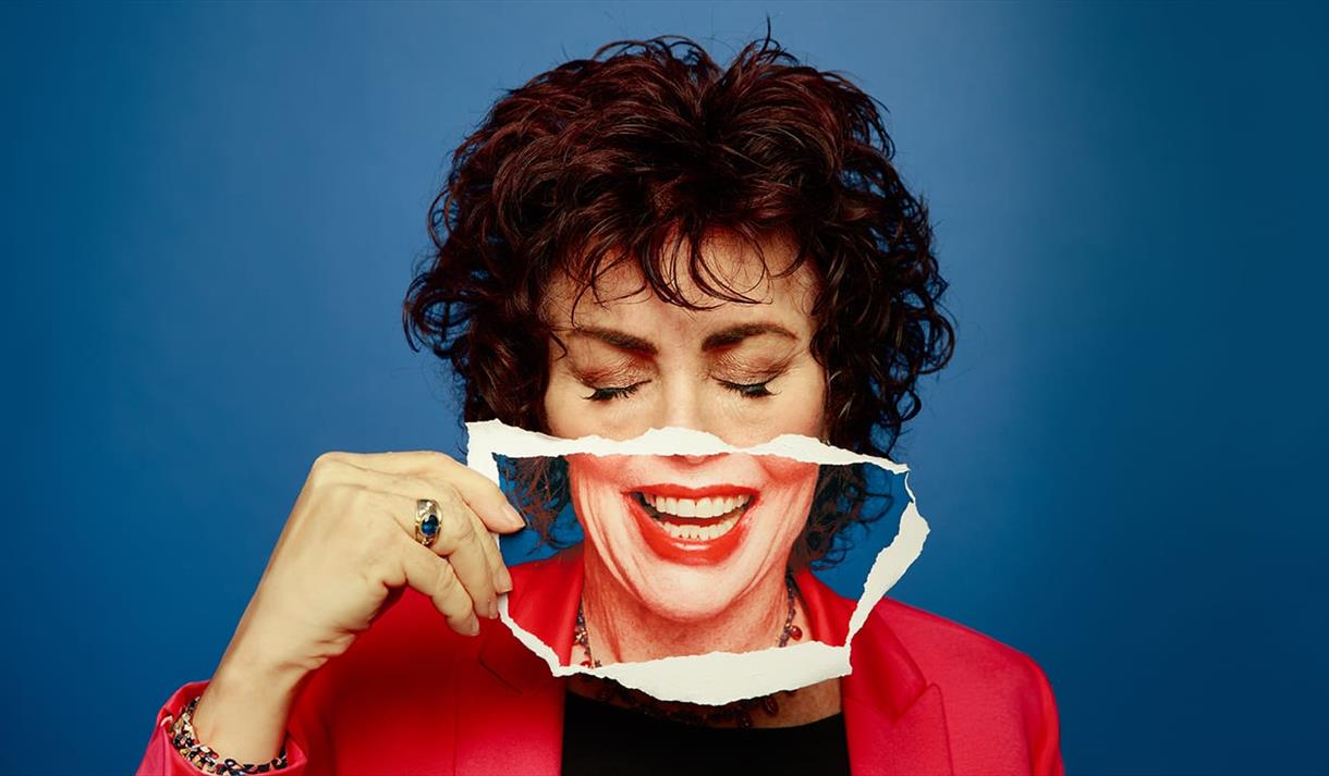 Photo of Ruby Wax holding a smile over her own face