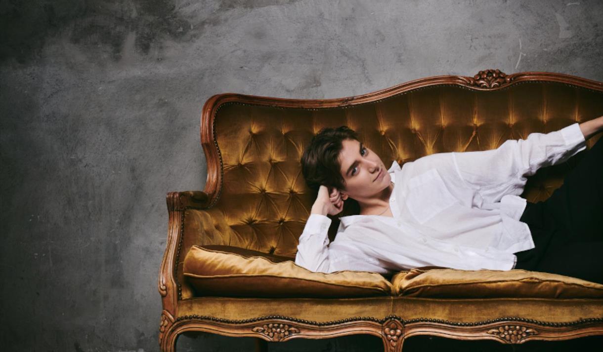 Photo of Sarah Keyworth lounging on a velvet couch