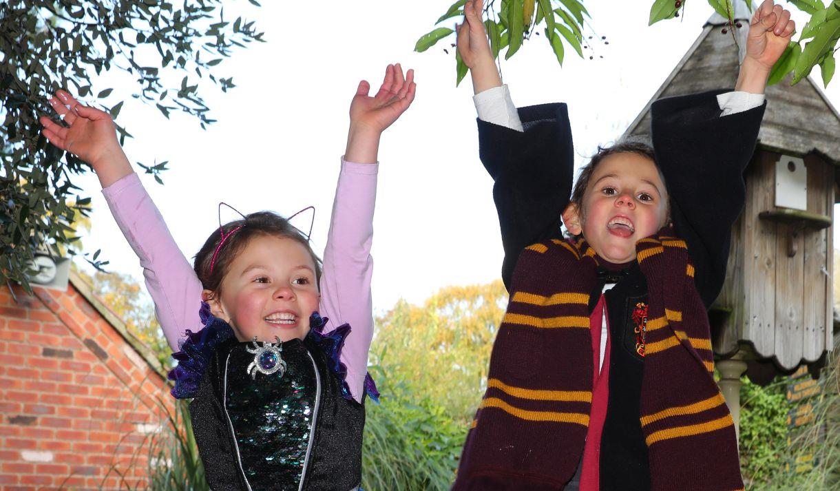 Photo of two young kids dressed as a witch and wizard