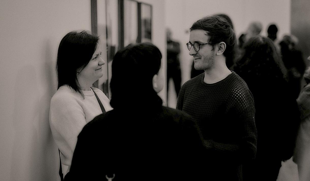 Black and white photo of visitors in the gallery