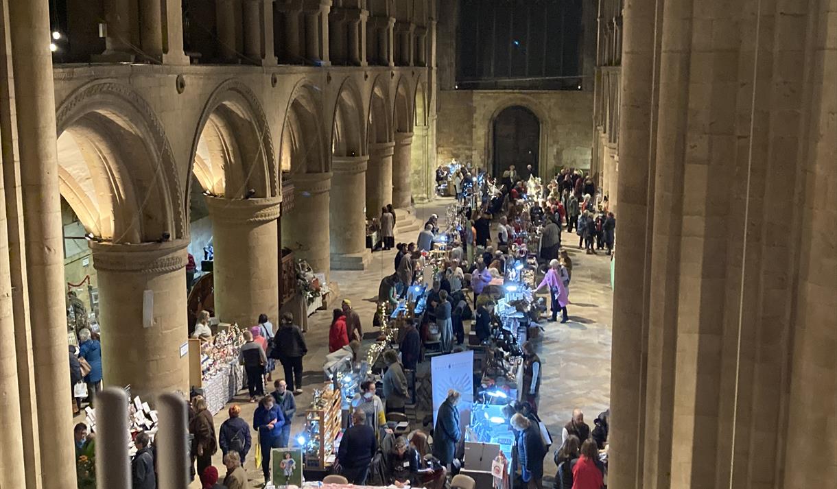 Aerial photograph of crowds gathered around craft stalls in Southwell Minster's central nave