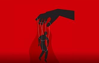 a red backdrop with a hand controlling a person posed as a puppet