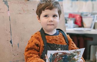 child with artwork they painted