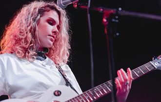 woman playing electric guitar