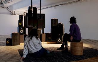 two people in front of speakers
