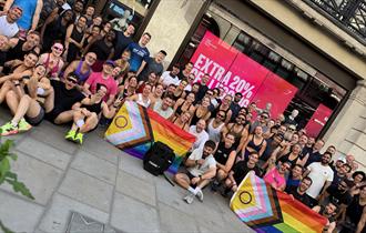 Group shot of participants in 5km run displaying Pride flags.