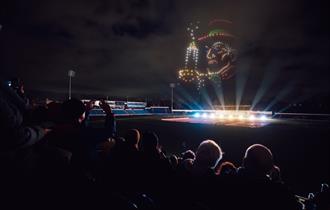 Photo of a drone show, depicting a figure from A Christmas Carol