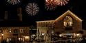 Fireworks behind the Engine Yard. The sky is dark and the fireworks stand out against the night sky.