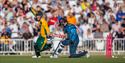 Photo of a cricket match showing two players mid-action