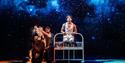 Production shot showing the actor and puppets on stage