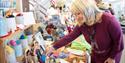 A customer browses a stall with crochet kits and handmade items