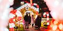 People walking up to a large gingerbread house