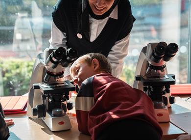 A child looking at a microscope