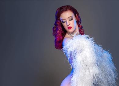 Photo of burlesque perfromer wrapped in a feather boa