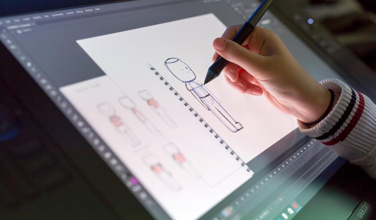 Photo of a person using a stylus on a digital screen, working on an animation piece.
