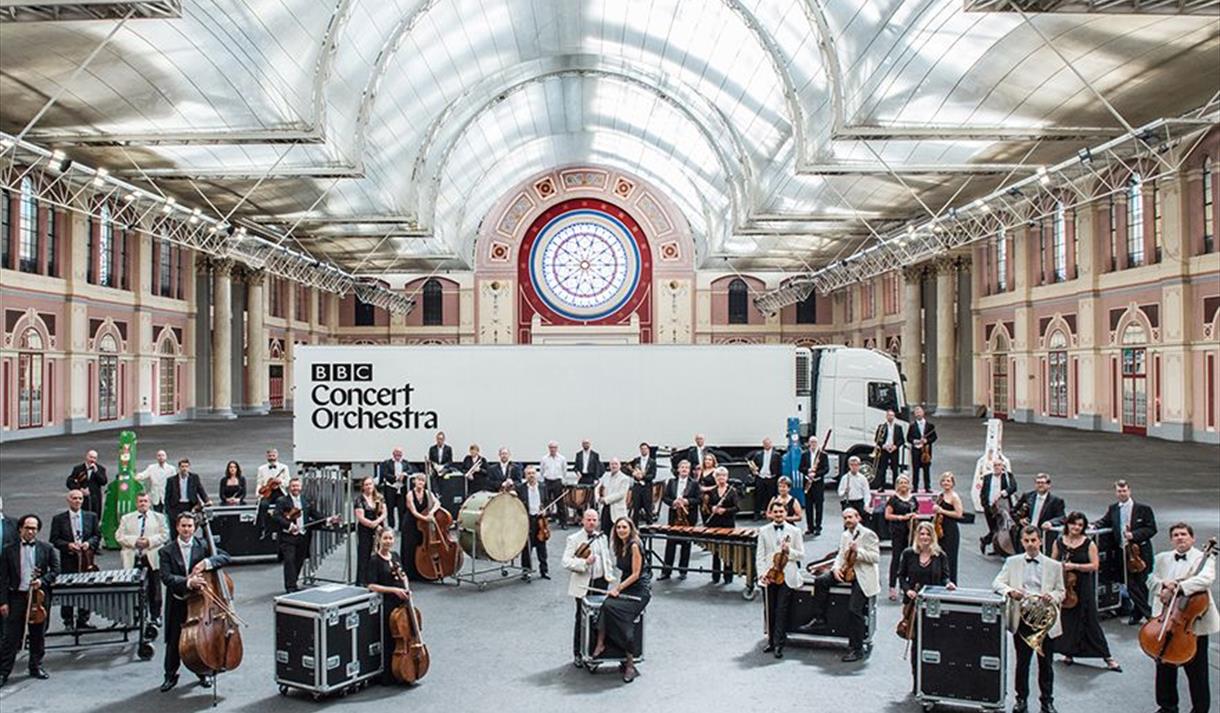 A graphic showing a deconstructed orchestra set-up in a grand room.