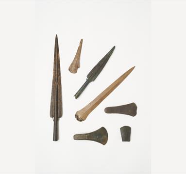 Photo of artefacts from avobe, including spears and other pointed materials.