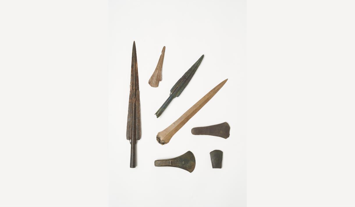 Photo of artefacts from avobe, including spears and other pointed materials.