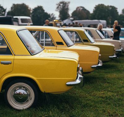 A photo of some classic cars parked in a row for a car show