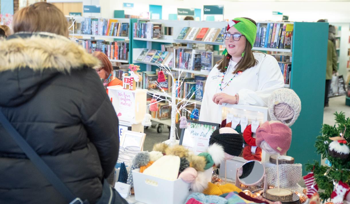 A person talking to a stallholder at a Christmas market A person talking to a stallholder at a Christmas market