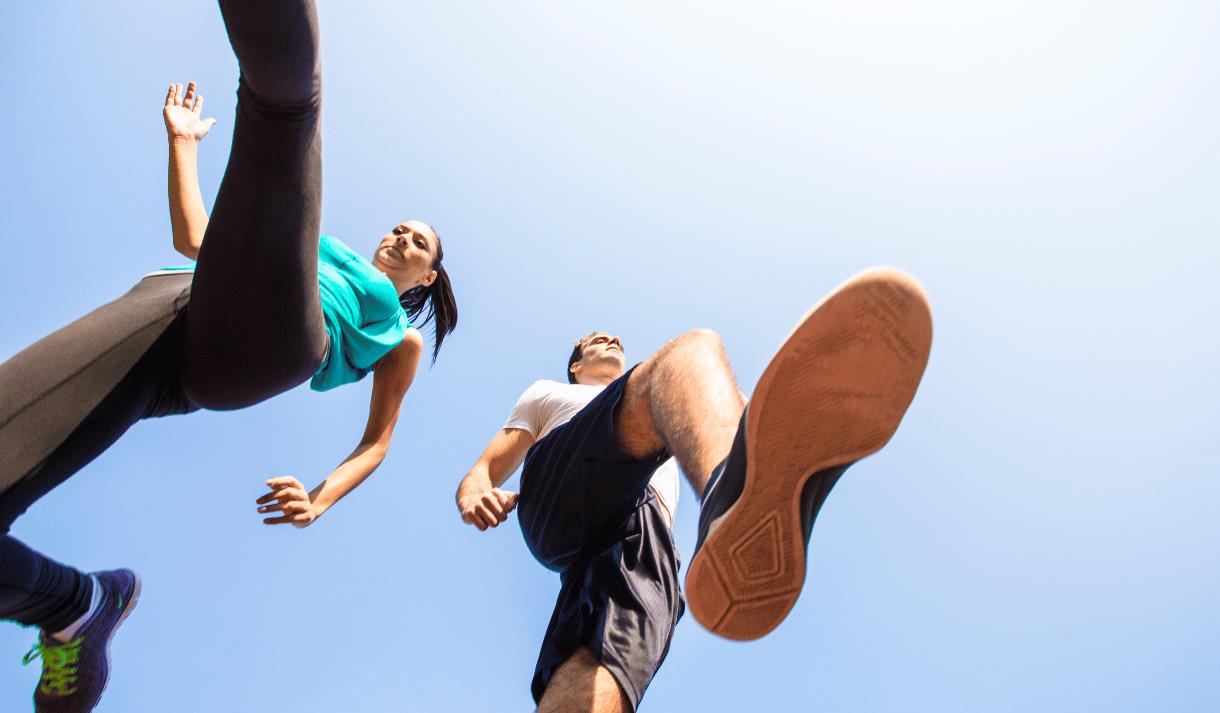 Photo of two runners, looking up at them from beneath their trainers