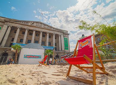 A beach photo with a deck chair in front of Nottingham City Centre Council House.